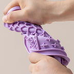 Hand bending a flexible purple silicone lick mat to show its soft texture | Pawnests