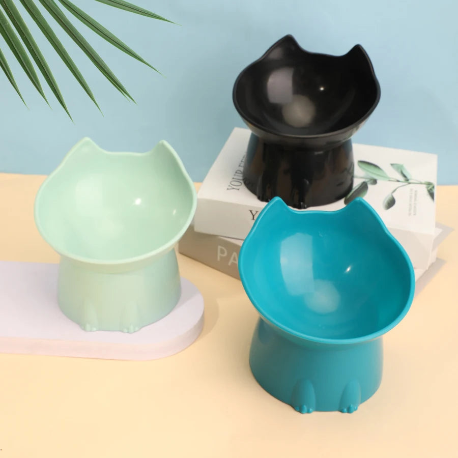 Green, black and blue raised tilted cat bowls on a pastel table | Pawnests