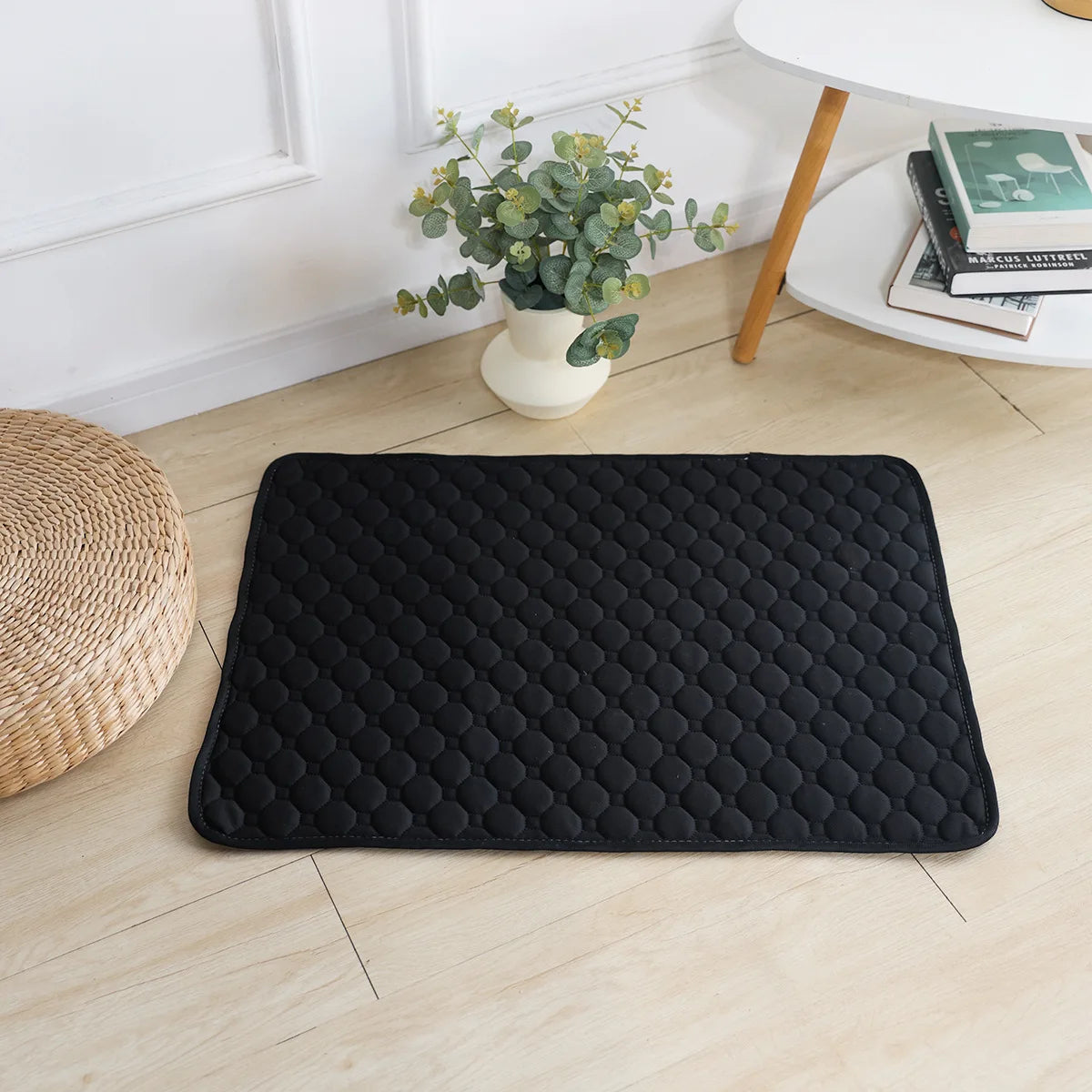 Black quilted washable dog pee pad on a wood floor | Pawnests