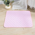 Pink quilted washable dog pee pad with piped edge on a wood floor | Pawnests