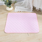 Pink quilted washable dog pee pad with piped edge on a wood floor | Pawnests